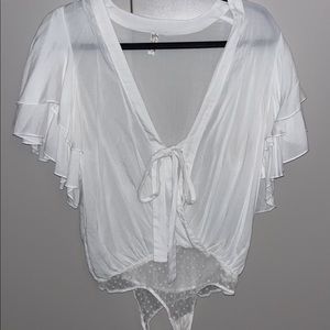 White bodysuit with detailed sleeves and polka dot mesh bottom